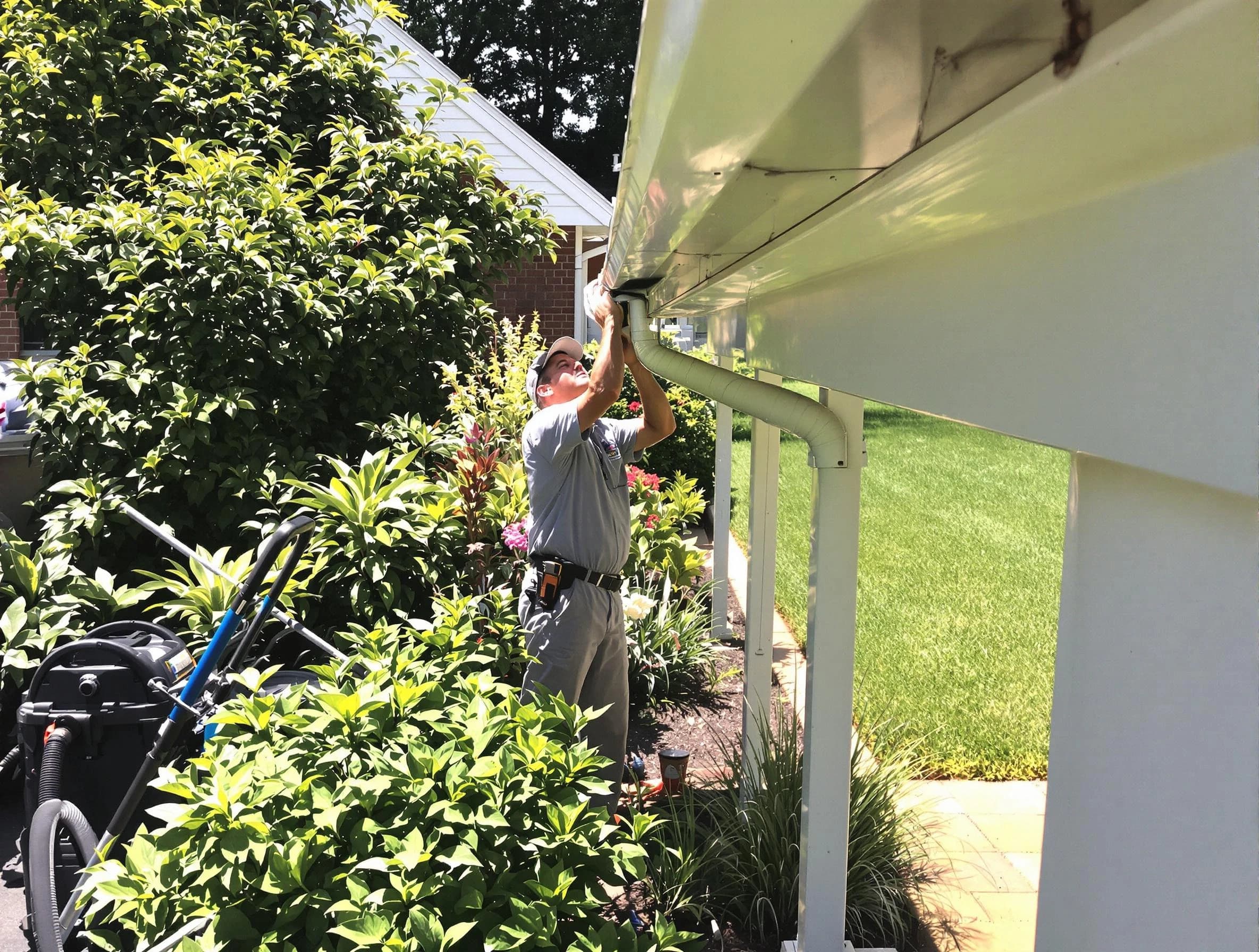 Technician flushing a blockage from a downspout in Akron, OH